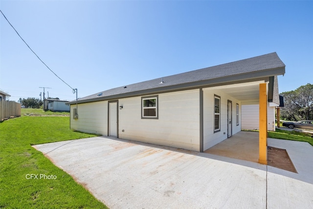 rear view of house with a patio and a lawn