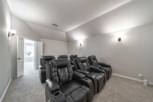 carpeted home theater room with lofted ceiling