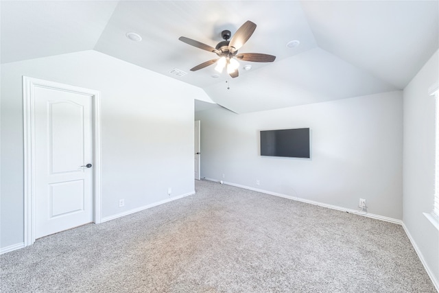 unfurnished room featuring ceiling fan, vaulted ceiling, and light colored carpet