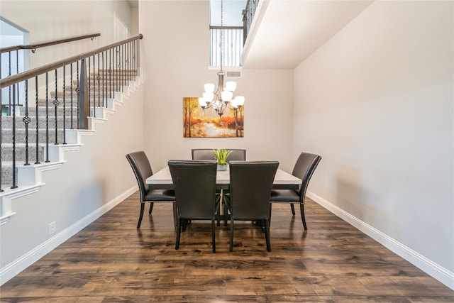 dining space featuring dark hardwood / wood-style flooring and a notable chandelier