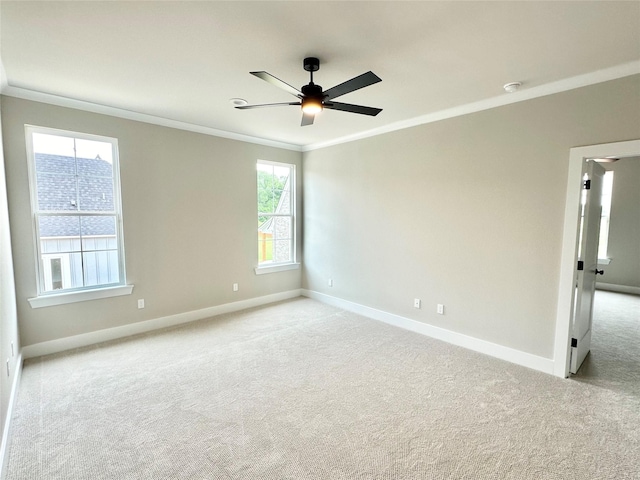 empty room featuring light carpet, ornamental molding, and ceiling fan