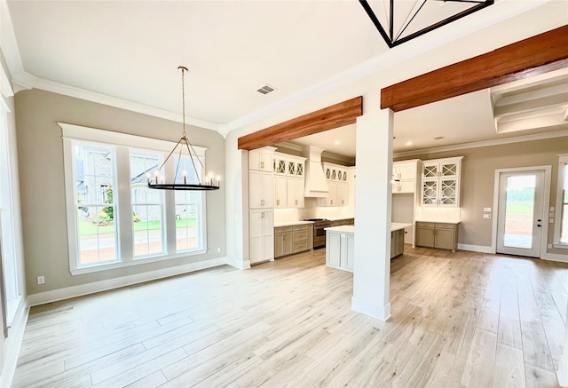 kitchen featuring premium range hood, pendant lighting, white cabinets, high end range, and a center island