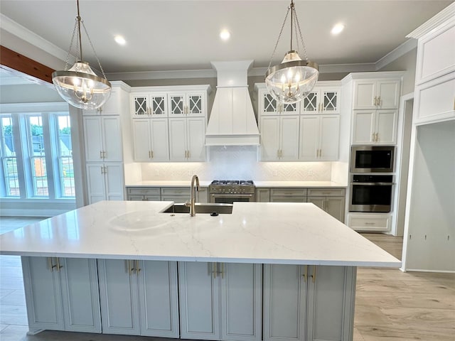 kitchen featuring premium range hood, stainless steel appliances, a spacious island, light stone counters, and decorative light fixtures