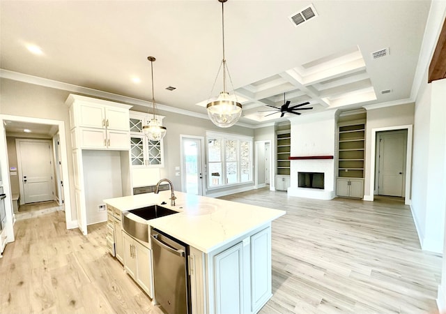 kitchen featuring sink, dishwasher, a kitchen island with sink, white cabinets, and decorative light fixtures