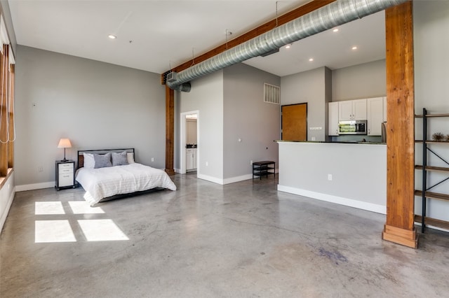 bedroom with concrete flooring and a high ceiling