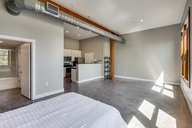 bedroom with connected bathroom and stainless steel refrigerator