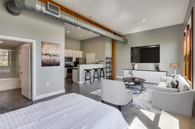 bedroom with stainless steel refrigerator and ensuite bath