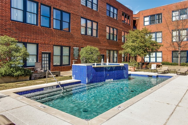 view of pool featuring pool water feature and a jacuzzi