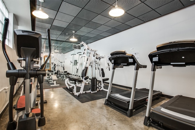 workout area with a drop ceiling and concrete floors