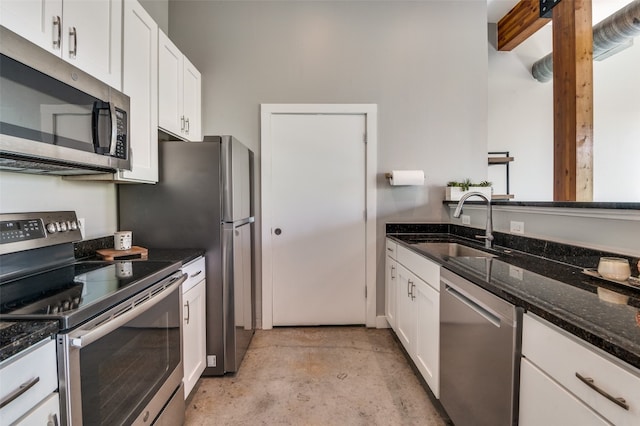 kitchen with white cabinetry, sink, appliances with stainless steel finishes, and dark stone countertops