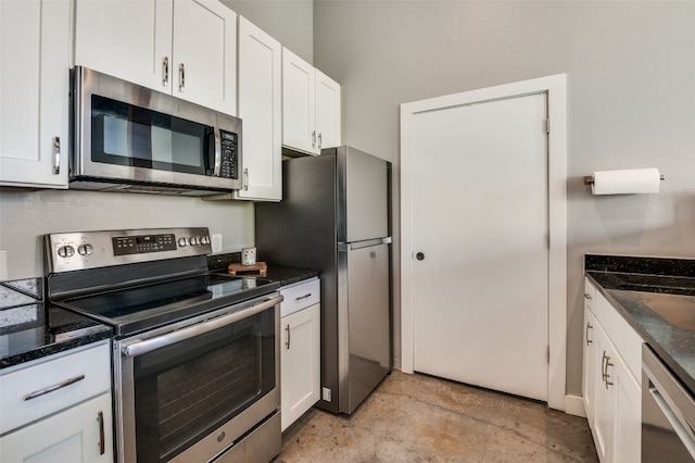 kitchen featuring white cabinetry, appliances with stainless steel finishes, and dark stone countertops