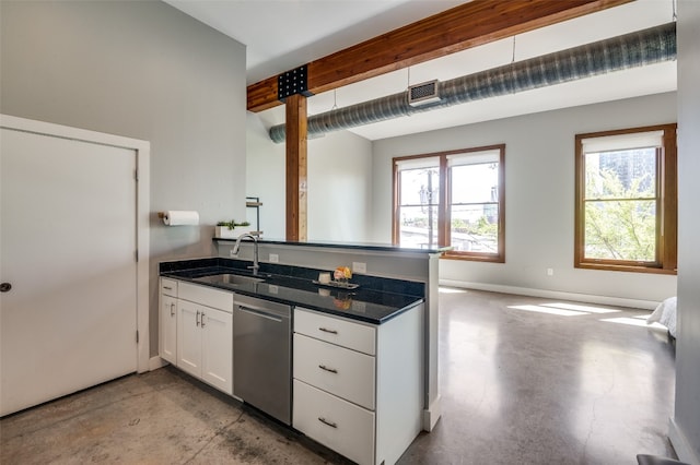 kitchen with white cabinets, stainless steel dishwasher, sink, and dark stone countertops