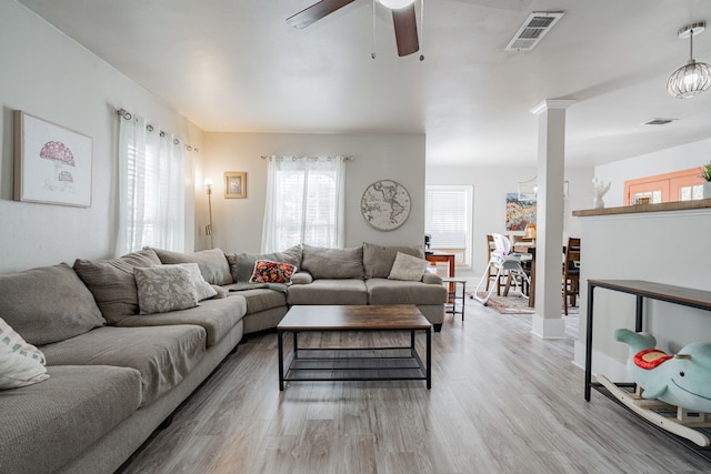 living room featuring light hardwood / wood-style flooring, ornate columns, and ceiling fan