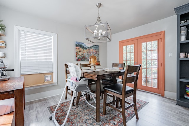 dining area featuring french doors, light hardwood / wood-style flooring, and a chandelier