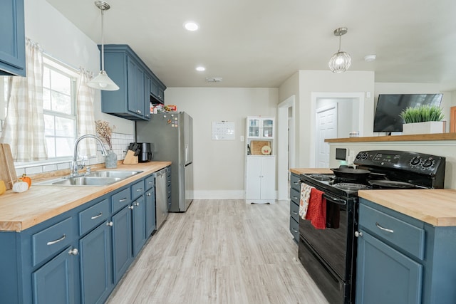 kitchen with wooden counters, blue cabinets, sink, and electric range