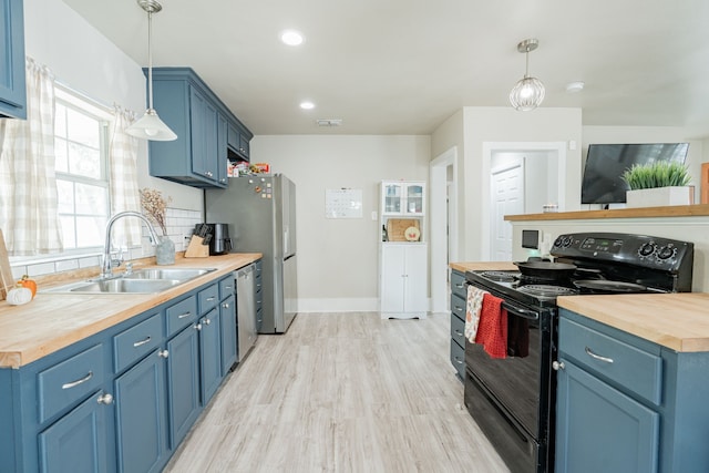 kitchen featuring appliances with stainless steel finishes, sink, light hardwood / wood-style floors, wooden counters, and blue cabinetry