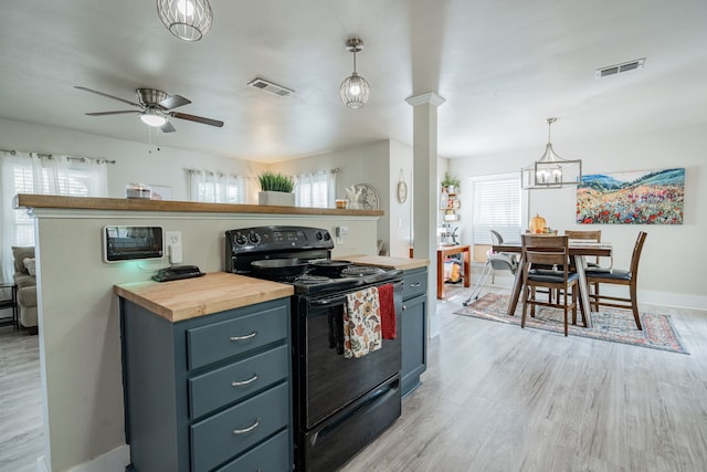 kitchen with black range with electric stovetop, light hardwood / wood-style flooring, butcher block counters, ceiling fan with notable chandelier, and pendant lighting