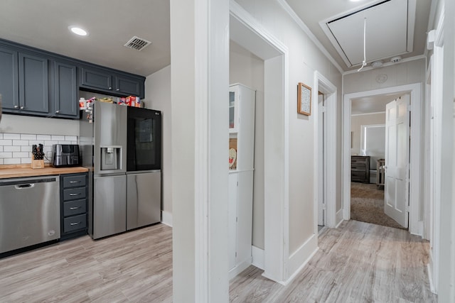 kitchen featuring wooden counters, appliances with stainless steel finishes, light hardwood / wood-style flooring, and backsplash