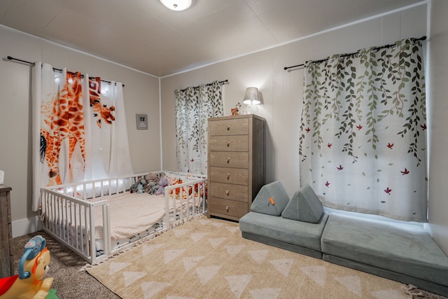 carpeted bedroom featuring a crib