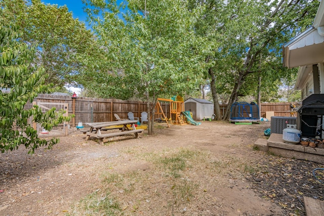 view of yard with a storage unit, a trampoline, and a playground