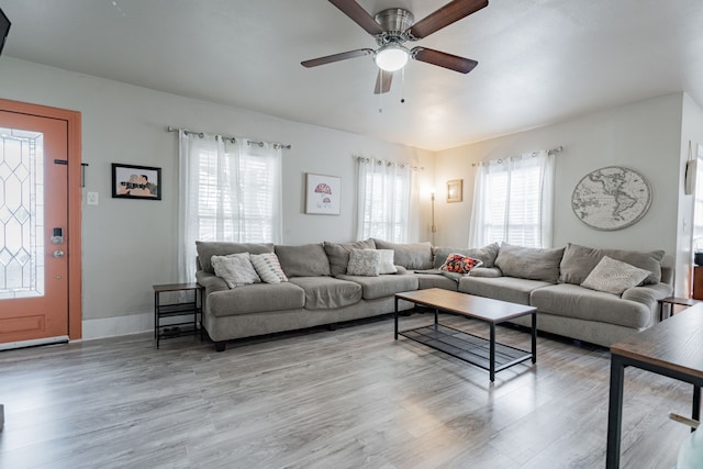 living room with ceiling fan and light hardwood / wood-style flooring