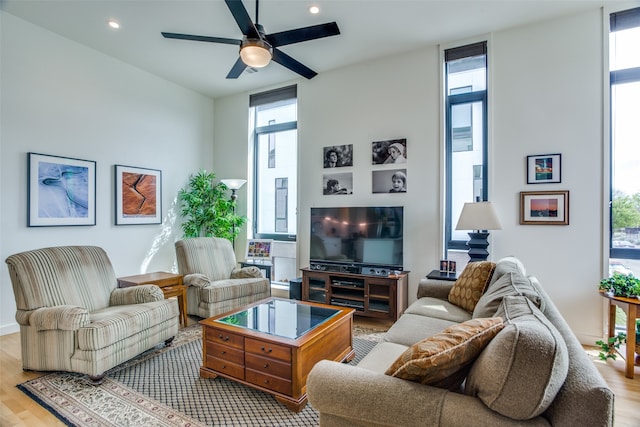 living room featuring ceiling fan, expansive windows, wood finished floors, and recessed lighting