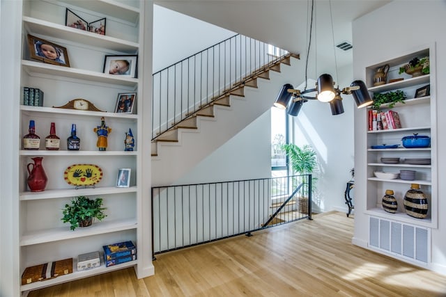 stairs featuring built in shelves, visible vents, and wood finished floors