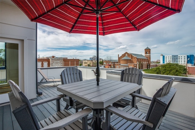 wooden terrace with a view of city and outdoor dining space