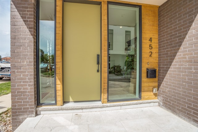 property entrance featuring brick siding