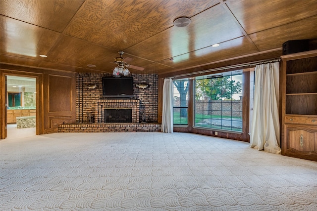 unfurnished living room featuring carpet, ceiling fan, wooden ceiling, and a brick fireplace