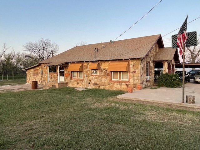 rear view of house featuring a lawn and a carport