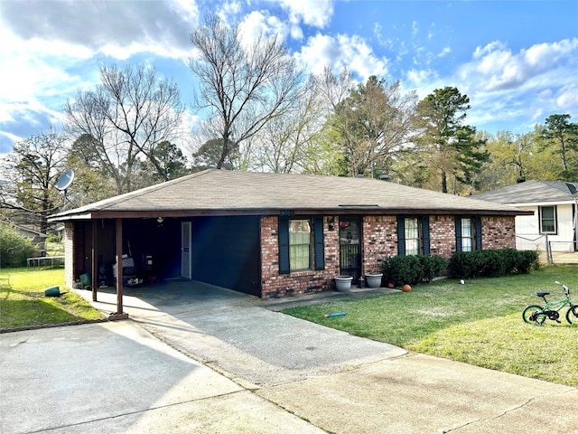 single story home with an attached carport, concrete driveway, brick siding, and a front yard