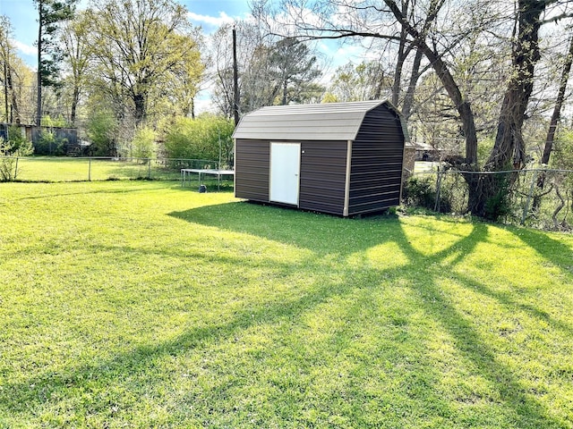 view of yard with a storage shed, a trampoline, an outdoor structure, and a fenced backyard