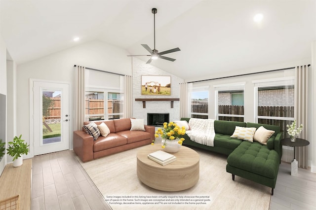 living room with a large fireplace, light hardwood / wood-style flooring, and a healthy amount of sunlight