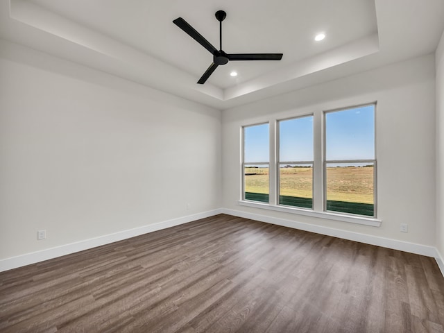 spare room featuring ceiling fan, a raised ceiling, and hardwood / wood-style floors