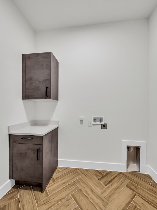 laundry room featuring cabinets, hookup for a washing machine, light parquet floors, and electric dryer hookup