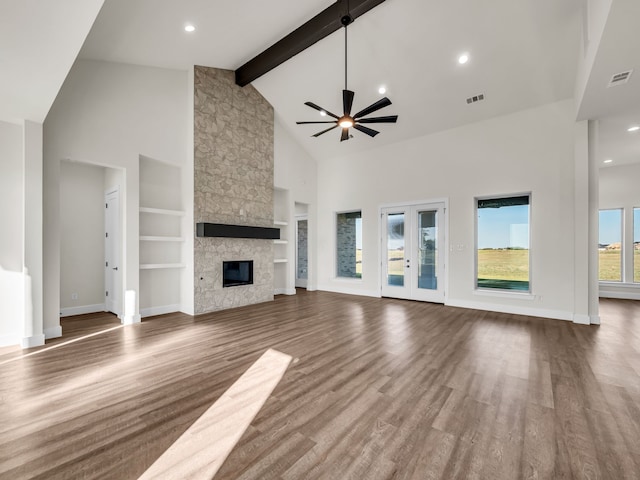 unfurnished living room featuring wood-type flooring, a fireplace, high vaulted ceiling, and beamed ceiling