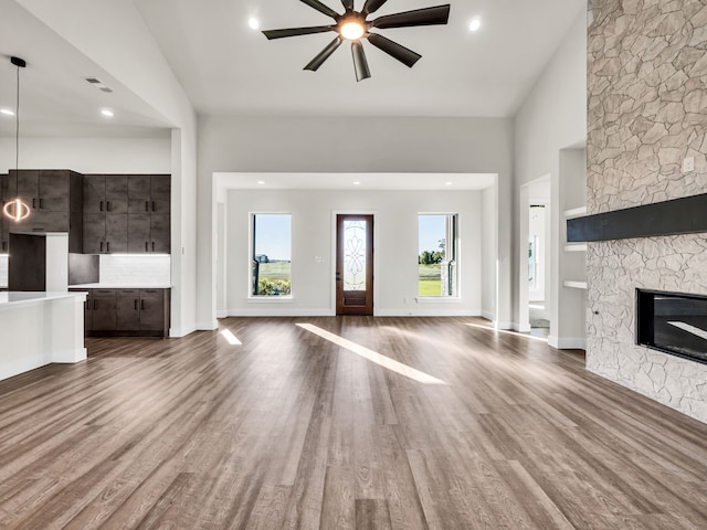 unfurnished living room with hardwood / wood-style floors, a wealth of natural light, and a fireplace