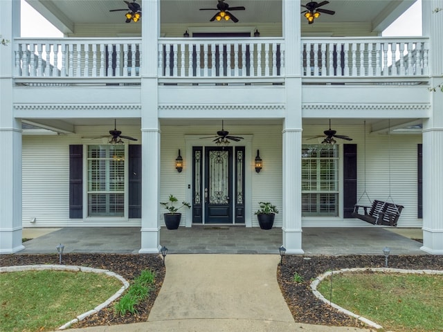 entrance to property with ceiling fan, a patio area, and a balcony