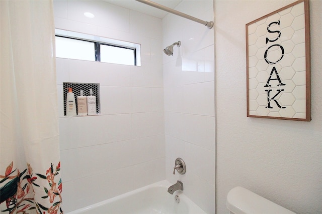 bathroom featuring toilet and shower / tub combo with curtain