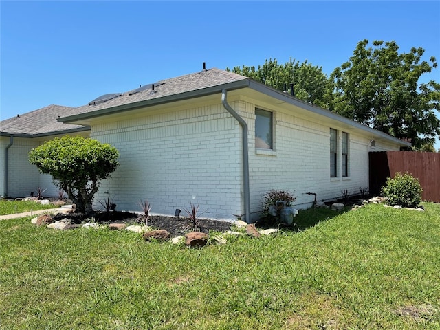 view of side of home with a lawn