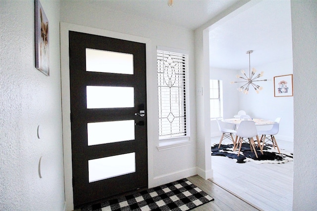 entrance foyer with a chandelier and wood-type flooring