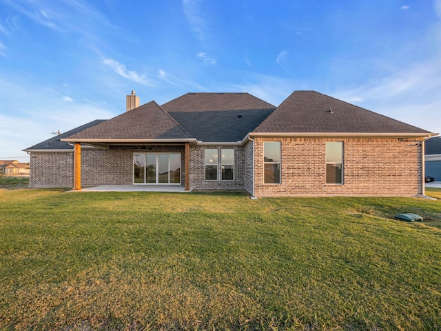 back of property featuring a yard and a patio