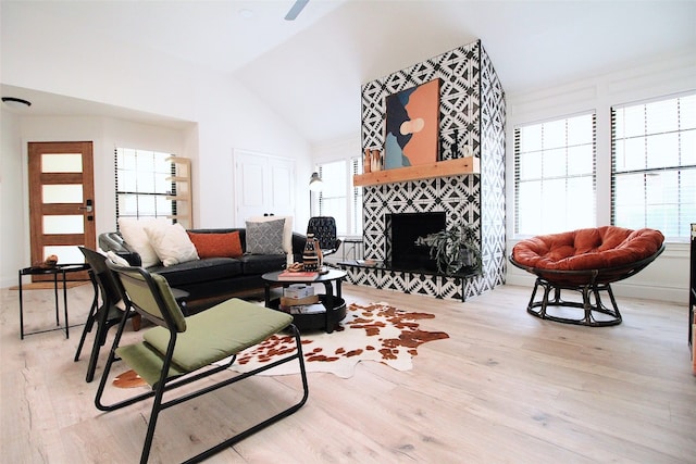 living room with light hardwood / wood-style floors, a fireplace, and lofted ceiling