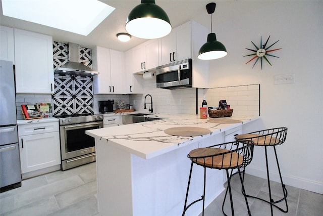 kitchen with white cabinets, appliances with stainless steel finishes, backsplash, and sink