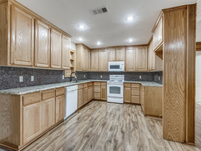 kitchen with sink, light stone counters, light brown cabinetry, white appliances, and light wood-type flooring