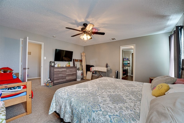 carpeted bedroom with ceiling fan and a textured ceiling