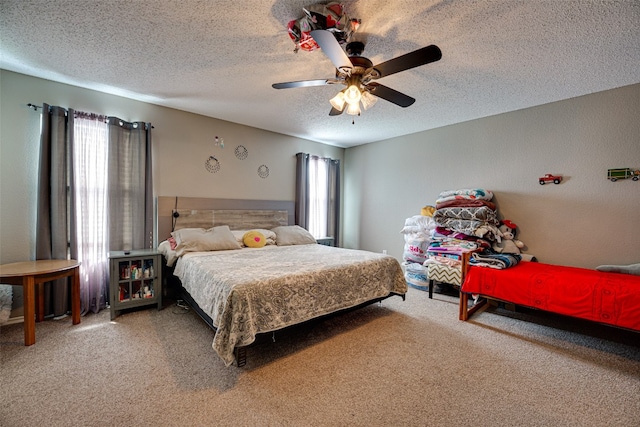 bedroom with ceiling fan, a textured ceiling, carpet, and multiple windows