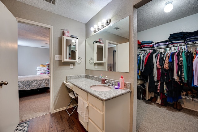 bathroom featuring hardwood / wood-style flooring, a textured ceiling, and oversized vanity