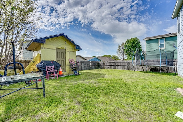 view of yard featuring a storage unit and a trampoline